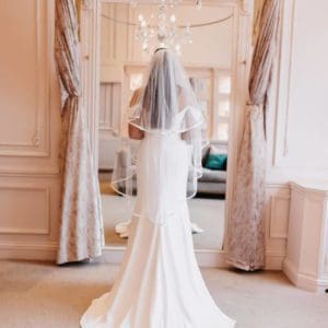 The Hattie is a 2 Tier Veil in classic tulle, decorated all the way around with a 10mm flat ribbon. Click to shop now.